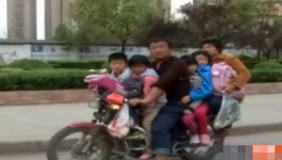 超载摩托车马路演“杂技”载六人飞驰