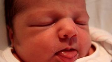 刚出生的婴儿小宝宝吐着小舌头卖萌，真是太可爱了