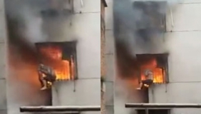 男子被困火海扒窗大声呼救 路人淡定录42秒未施救