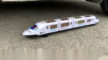 牛人把玩具火车放到车轮下面，实在是太减压了，挺过瘾的