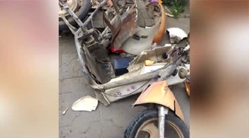 轿车小巷内疯狂驶过 撞碎一排摩托车