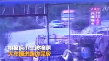 货车与轿车相撞 掀翻小车后撞进路边民房