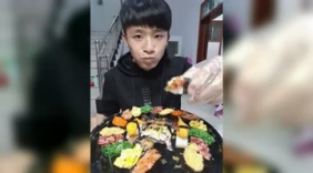帅哥端着一盘寿司拼盘吃的津津有味 看帅哥吃的这么香 馋死我了