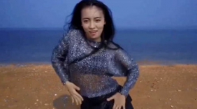 美女在沙滩上秀了段舞蹈，海风吹起长发，太美了！