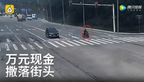 监拍骑车男万元现金撒落街头 男子阻止他人哄抢冒领