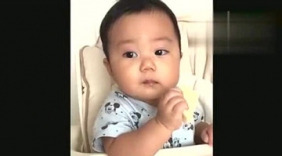 萌宝自己乖乖坐着吃东西，一看到妈妈就开始笑，可爱极了