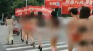 南宁女模特穿比基尼举广告牌穿梭闹市 众路人围观
