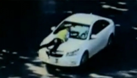 无牌轿车遇查 男子驾车顶辅警狂飙百米