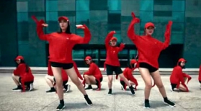 美女舞蹈团队身穿红衣，高楼前大跳现代舞