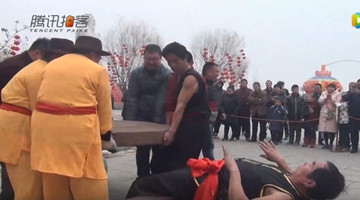 庙会牛人秀硬气功绝活 千斤磨盘覆身无压力