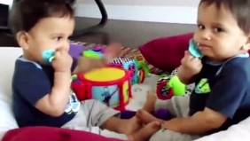 双胞胎萌娃不约而同抢对方嘴里的奶嘴，好可爱啊