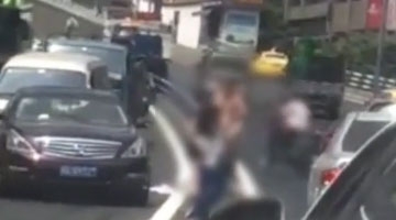 一女子光着上身与两女子马路中间对战 致交通堵塞